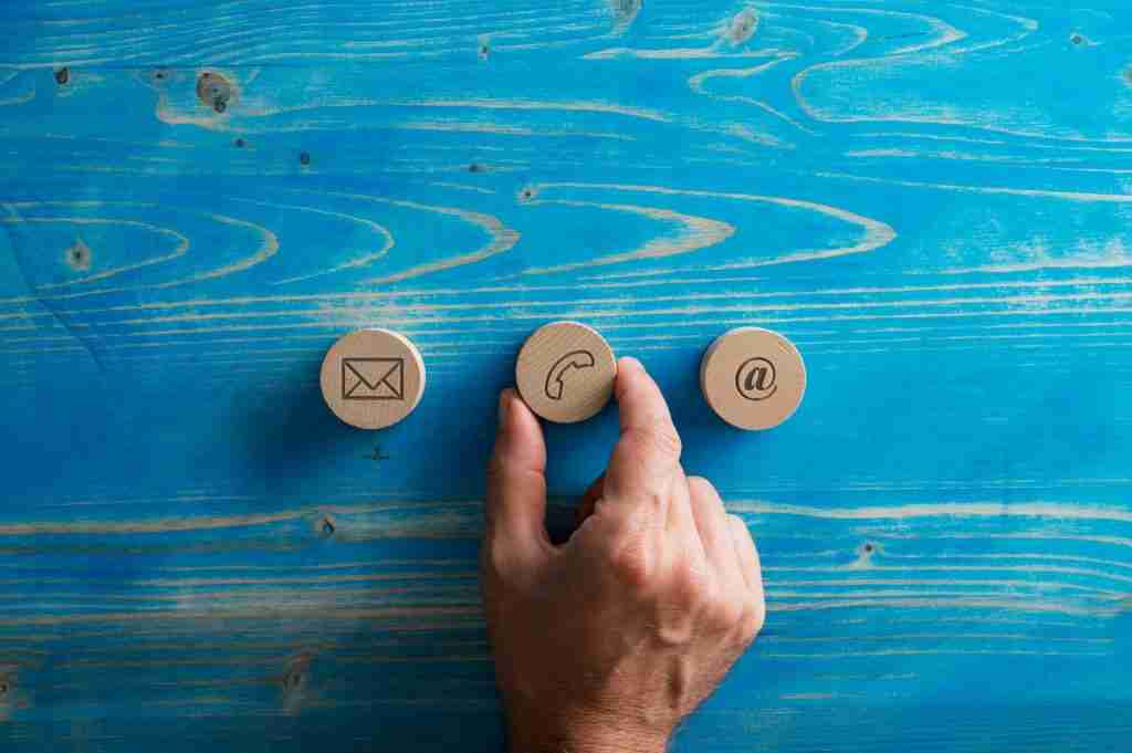 Three wooden cut circles with contact and communication icons on them